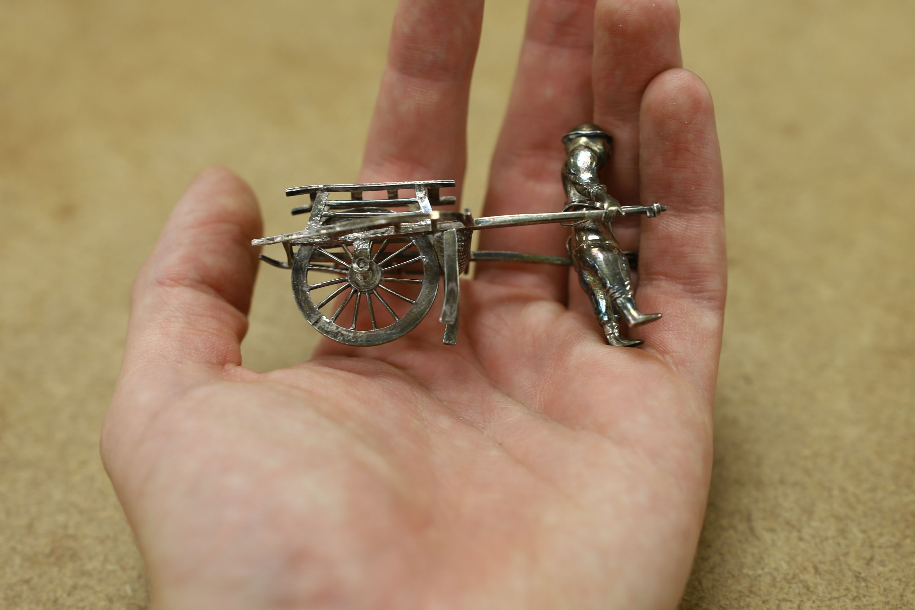 Six assorted miniature white metal items including a Chinese tea kettle on stand (lacking lid), height 93mm, maker CS, a similar rickshaw with driver, maker CH, a Chinese condiment and three other items.
